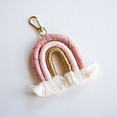 a pink and gold keychain with a tassel hanging from it's side