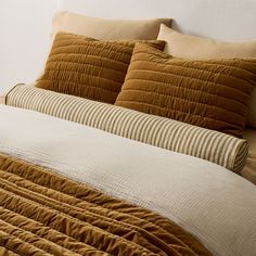 a bed with brown and white pillows on top of it