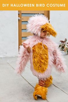 a little boy dressed in a chicken costume and standing next to a door with his hands on his hips