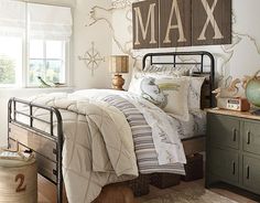 a bed room with a neatly made bed next to a window and a wooden sign on the wall