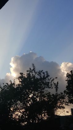 the sun shines brightly through clouds over trees