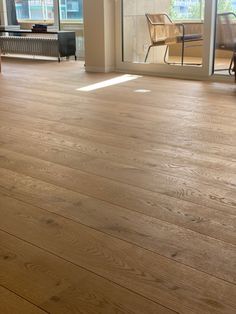 an empty living room with hard wood flooring and sliding glass doors to the outside