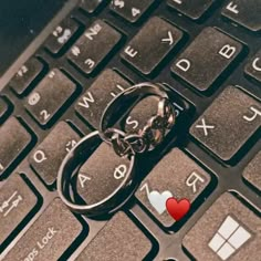 a keychain that has been placed on top of a keyboard with a heart