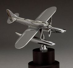 a silver model airplane sitting on top of a black stand