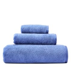 three blue towels stacked on top of each other in front of a white background,