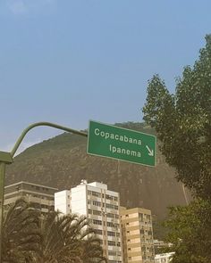 a green street sign hanging from the side of a metal pole