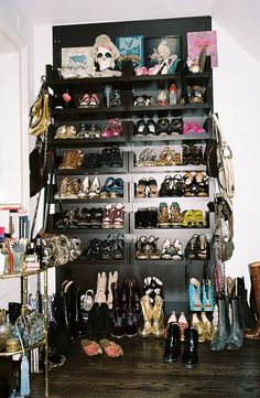 there are many shoes and purses on the shelves in this room that is full of them