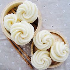 three bowls filled with food next to chopsticks on top of a white table cloth