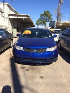 two cars are parked in front of a building with a for sale sign on it