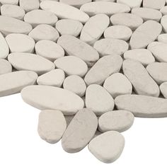 a pile of white rocks sitting next to each other on top of a white surface