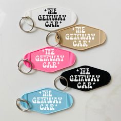 four different colored key chains with the words the getaway car and the genway car on them