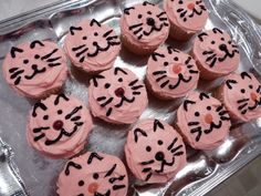 cupcakes decorated with pink frosting and black cat faces on top of each other