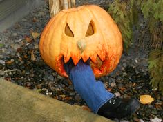 a person holding a pumpkin with its mouth open