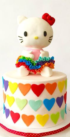 a hello kitty cake is decorated with hearts