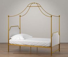 a gold metal bed frame with white sheets