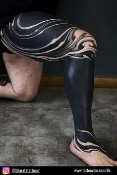 a man with black and white tattoos on his legs