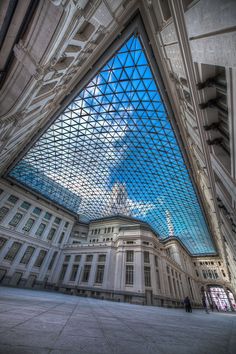 the inside of a building with a glass roof and skylight above it, as seen from below