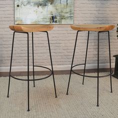 two stools sitting next to each other in front of a painting