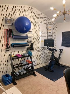 a room with exercise equipment and wallpaper on the walls, including an exercise bike