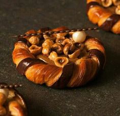 there are many croissants with nuts in them on the table and one has a bead around it