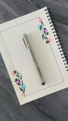 a notepad with a pen on top of it next to a spiral bound notebook