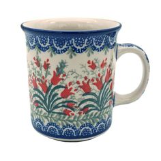 a blue and white cup with red flowers on it