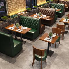 an empty restaurant with green booths and wooden tables