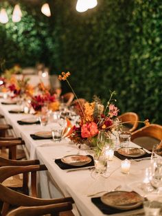 a long table is set with place settings for dinner