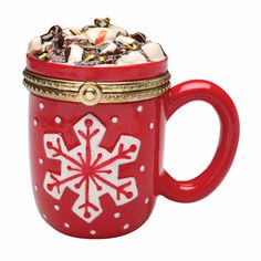 a red mug filled with candy and marshmallows on top of a white background