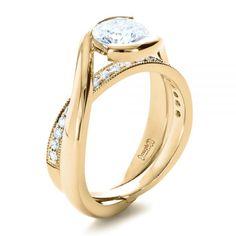 a yellow gold engagement ring with an oval cut diamond in the center and side stones