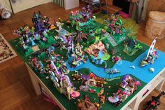 a table with many toys on it in the middle of a living room and dining area