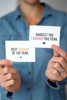 two women holding cards with the words best moment of the year written on them