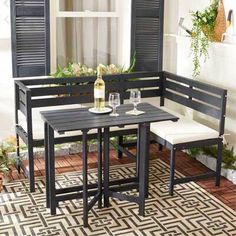 a set of three benches and table with wine glasses on it in front of a window