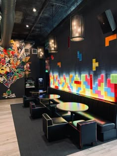 a restaurant with black booths and colorful artwork on the wall