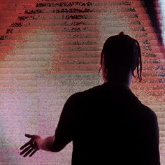 a man standing in front of a large screen with his hands out to the side