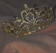 a gold tiara sitting on top of a pink cloth