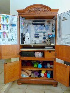 an open cabinet with lots of crafting supplies on it's doors and shelves