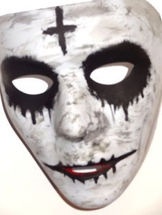 a white mask with black and red paint on it