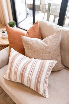 some pillows are sitting on a couch in front of a sliding glass door