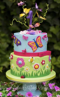 a multi layer cake decorated with butterflies and flowers