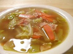 a white bowl filled with soup on top of a wooden table