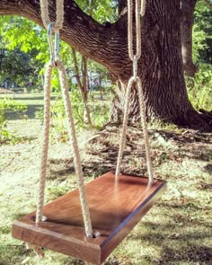 a wooden swing hanging from the side of a tree