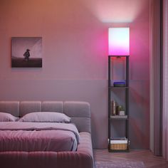 a bed sitting next to a pink light in a bedroom