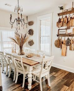 a dining room table with chairs and a chandelier hanging from it's ceiling