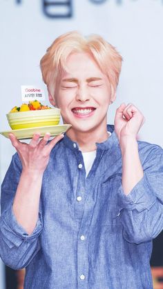 the young man is holding up a cake