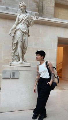 a woman standing in front of a statue