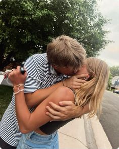 a man and woman hugging each other on the street