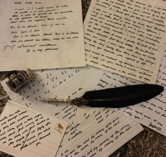 several pieces of paper with writing on them and an ink pen laying next to it