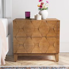 a wooden dresser with vases and flowers on top