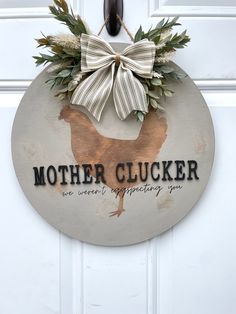 a white door with a sign that says mother clucker and a bow on it